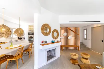 a kitchen and dining room with a table and a fireplace at Protaras Rose By The Sea Villa in Protaras