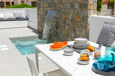 a table with plates of food on it next to a pool at Protaras Rose By The Sea Villa in Protaras