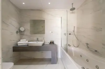 a bathroom with a tub and a sink and a shower at MARGADINA HOTEL in Ayia Napa