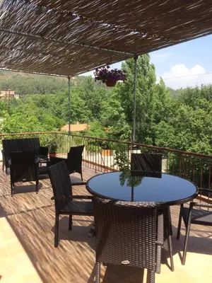 a patio with a table and chairs on a deck at AYIOS NICOLAOS RIVER PARK in Perapedhi