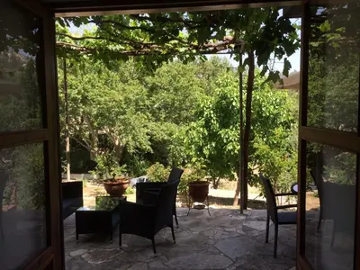 a patio with chairs and tables and trees at AYIOS NICOLAOS RIVER PARK in Perapedhi
