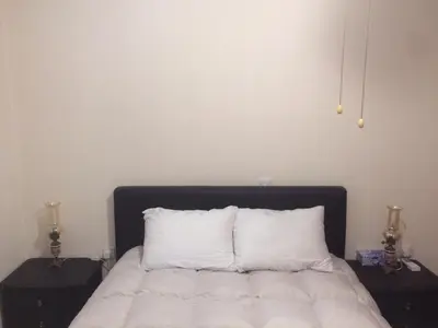 a bedroom with a bed with white sheets and two night stands at AYIOS NICOLAOS RIVER PARK in Perapedhi