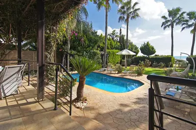 a swimming pool in a yard with palm trees at Villa Polina in Ayia Napa