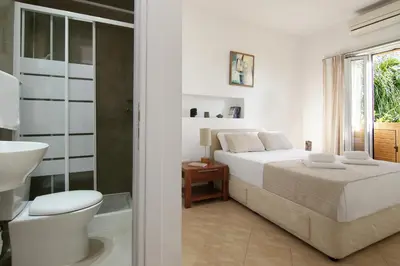 a white bedroom with a bed and a bathroom at Villa Polina in Ayia Napa