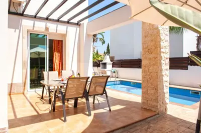 a patio with a table and chairs next to a swimming pool at Villa Danata in Protaras