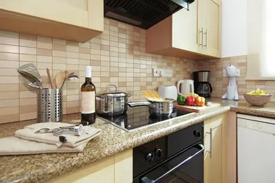 a kitchen counter with a stove and a bottle of wine at Villa Danata in Protaras