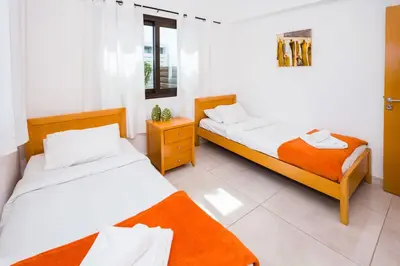 two beds in a room with white walls at Villa Abdera - 4bed with Private Pool in Protaras