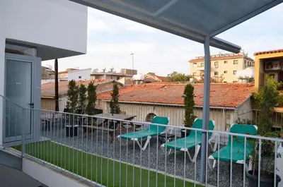 a balcony with green chairs and a table at St. Lazaros Studios in Larnaka