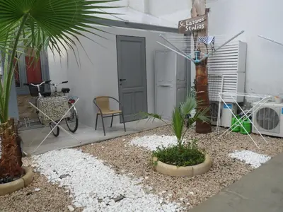 a patio with a sign and a chair and a palm tree at St. Lazaros Studios in Larnaka