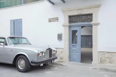 a car parked in front of a building with a blue door at St. Lazaros Studios in Larnaka