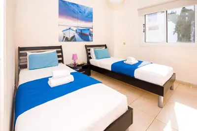 a bedroom with two beds and a window at Villa Emily in Protaras
