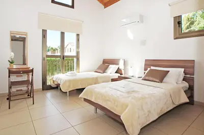 a hotel room with two beds and a balcony at Villa Louisa in Ayia Napa