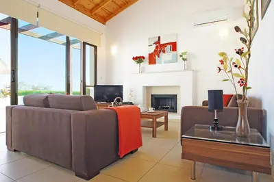 a living room with two couches and a fireplace at Villa Louisa in Ayia Napa