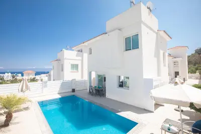 a villa with a swimming pool and a house at Romeo & Juliet in Protaras