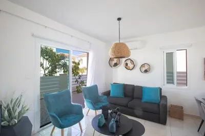 a living room with a couch and blue chairs at Romeo & Juliet in Protaras