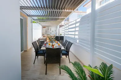 a dining room with a long table and chairs at Protaras Villa Dafni in Protaras