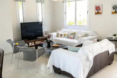 a living room with two couches and a flat screen tv at Protaras Villa Dafni in Protaras