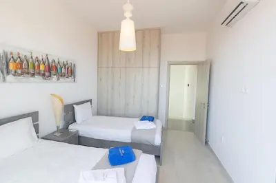 a hotel room with two beds and a mirror at Sol E Mar Villas ( Gold Emerging Villas ) in Protaras