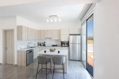 a kitchen with a table and two chairs in it at Sol E Mar Villas ( Gold Emerging Villas ) in Protaras