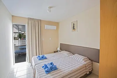 a bedroom with a bed with blue towels on it at Merab Holidays Apartment Castalia 62 in Ayia Napa