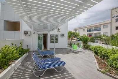 a patio with two lounge chairs and awning at Merab Holidays Apartment Castalia 62 in Ayia Napa