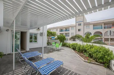 a patio with chairs and tables and awning at Merab Holidays Apartment Castalia 62 in Ayia Napa
