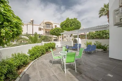 a patio with a table and chairs and a fence at Merab Holidays Apartment Castalia 62 in Ayia Napa