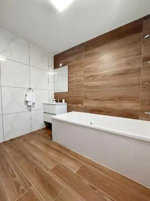 a bathroom with a white tub and wooden walls at Agros Green Valley Suites in Limassol