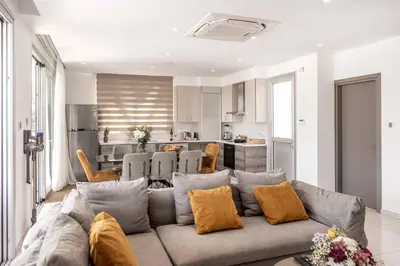 a living room with a couch and a kitchen at Villa Green Haven 2 Protaras Cyprus in Protaras
