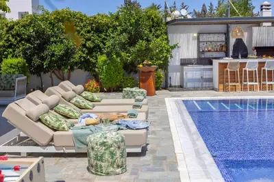 a patio with couches and a pool next to a house at Villa Green Haven 2 Protaras Cyprus in Protaras