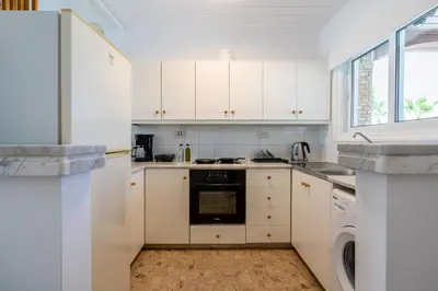 a kitchen with white cabinets and a dishwasher at Keylana's 2-BR Apt in Pyla in Pyla