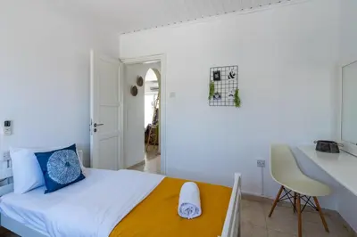 a white bedroom with a bed and a desk at Keylana's 2-BR Apt in Pyla in Pyla