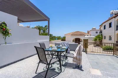 a patio with a table and chairs on a balcony at Keylana's 2-BR Apt in Pyla in Pyla