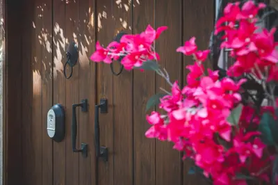 a bunch of pink flowers in front of a wooden door at Eidyllio Luxury Suites Omodos in Omodos