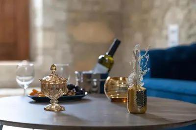 a table with a bottle of wine and a plate of food at Eidyllio Luxury Suites Omodos in Omodos