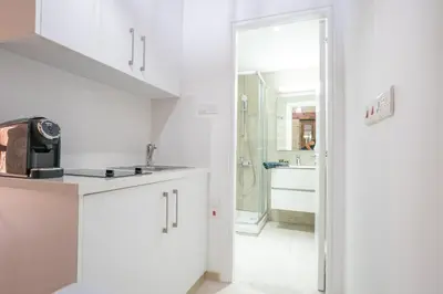 a kitchen with white cabinets and a sink at Eidyllio Luxury Suites Omodos in Omodos
