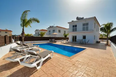 a villa with a swimming pool and a house at Nissi Villa Ourania in Ayia Napa