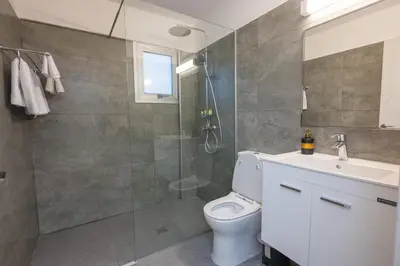 a bathroom with a shower and a toilet and a sink at Napa Centrale Suites in Ayia Napa
