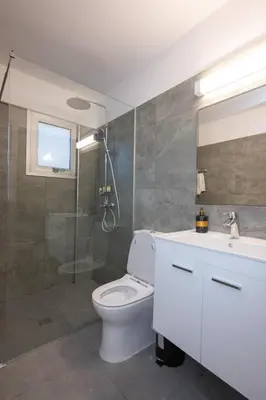 a bathroom with a toilet and a shower and a sink at Napa Centrale Suites in Ayia Napa