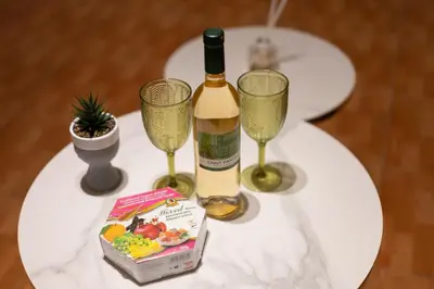 a white table with a bottle of wine and two glasses at Napa Centrale Suites in Ayia Napa