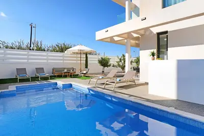 a villa with a swimming pool and a house at Villa Queen Valentina in Protaras