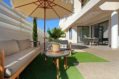 a patio with a couch and a table with an umbrella at Villa Queen Valentina in Protaras