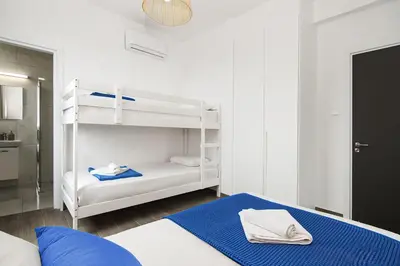 a bedroom with two bunk beds and a blue rug at Villa Queen Valentina in Protaras