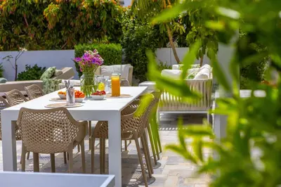 a white table with chairs and flowers on a patio at Green Heaven Villa 3 in Protaras