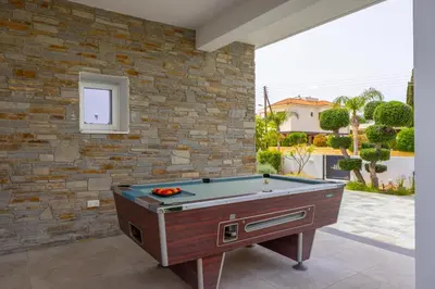 a pool table in front of a brick wall at Green Heaven Villa 3 in Protaras