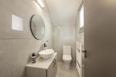 a bathroom with a sink and a toilet and a mirror at Green Heaven Villa 3 in Protaras
