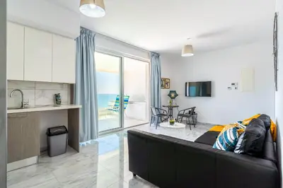 a living room with a couch and a kitchen at Oyster 1-BR Apt in Larnaca in Larnaka