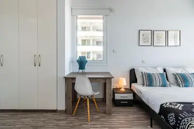 a bedroom with a bed and a desk and a chair at Oyster 1-BR Apt in Larnaca in Larnaka