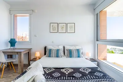 a bedroom with a bed and a desk and a window at Oyster 1-BR Apt in Larnaca in Larnaka