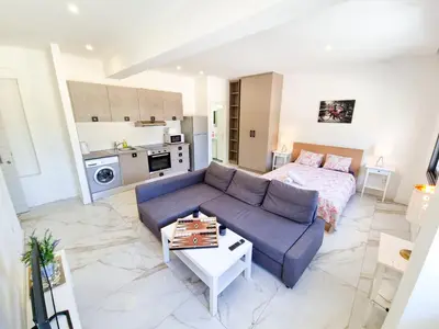 a living room with a blue couch and a bed at Happy Homes Paradise in Larnaka